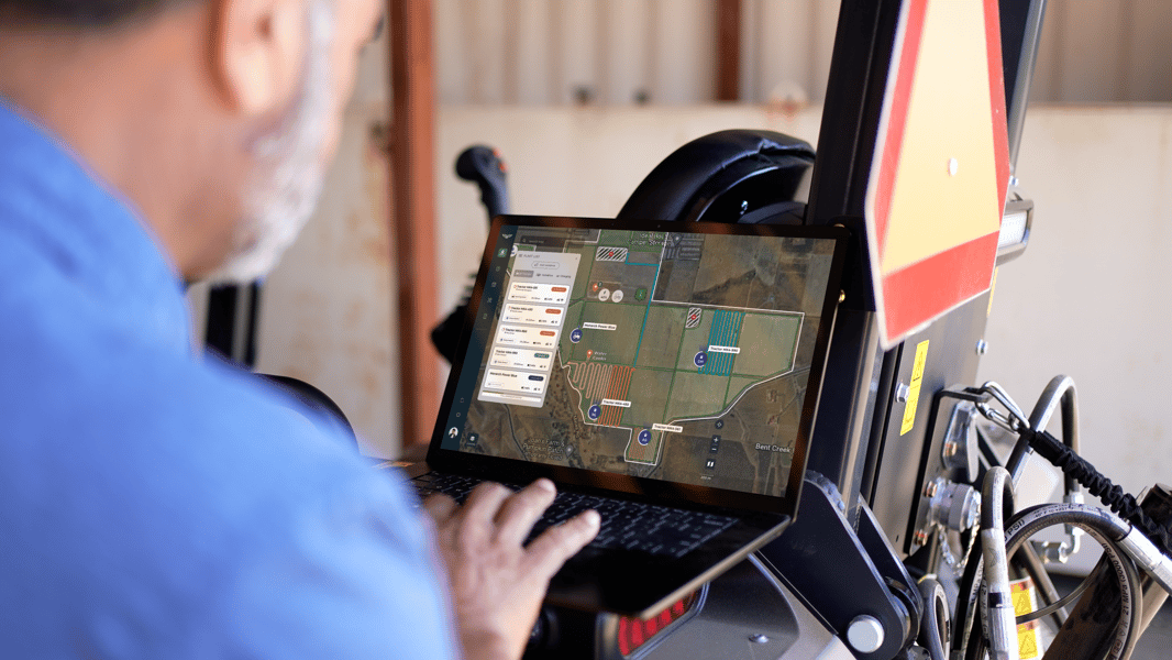 Farm manager looking at WingspanAI app to check MK-V electric tractor operation history.