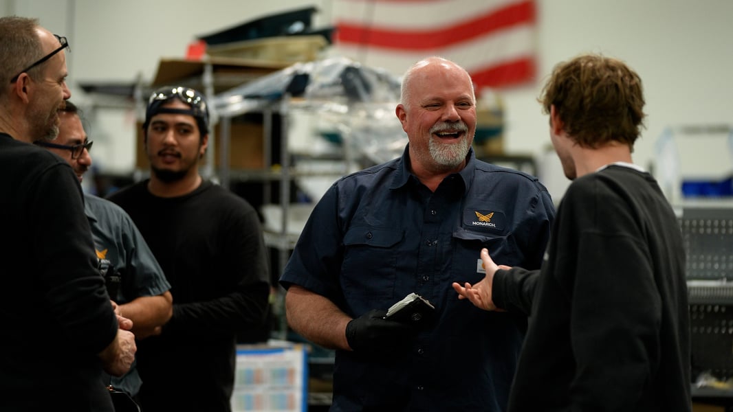 Five workers laugh and talk amongst each other at Monarch's production facility for the MK-V electric, autonomous and smart tractor.
