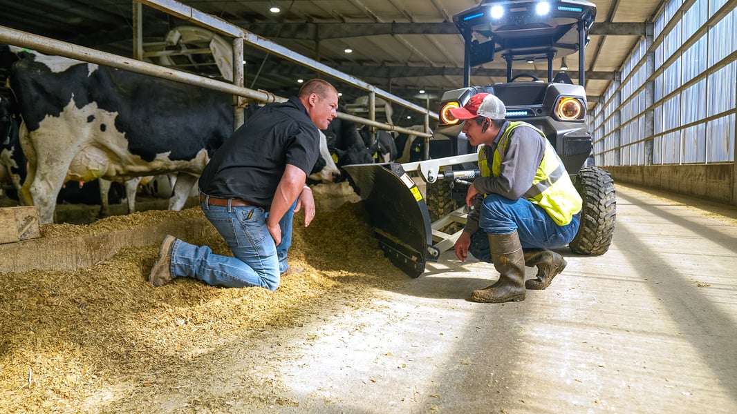 Dairy farm manager talks to a dairy worker in from the MK-V Dairy electric tractor.